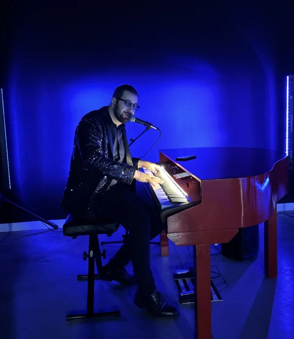 REYES al piano rojo con gafas azules. Piano y voz 100 % en directo.
